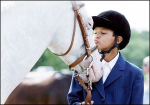 Darien Arthur, 10, of Swanton gives his pony Gaby a good-luck kiss before they enter the ring for competition at the fair. 