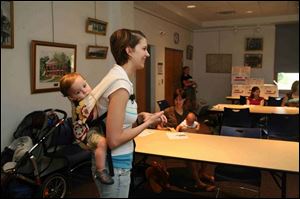 Holly Allen of Perrysburg 'wears  son Parker, 1 year old, in a sling.

