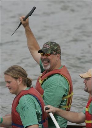 Mike Eck of the National City Green River Team, sponsored by National City Bank, waves to his fans as his boat heads for the starting line. The team with the best time was St. John s Jesuit High School s  Rowing Titans. 

