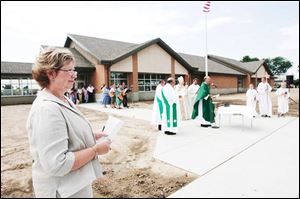 Holy Trinity Principal Linda Justen, foreground, takes in the dedication of the new $5 million Fulton County school in a cermony conducted by Bishop Leonard Blair.