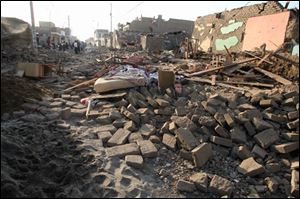 Residents in the town of Pico wait outside their houses, background, ruined by an earthquake that hit Peru late Wednesday.