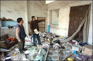 Members of the Peruvian Civil Defense inspect a building damaged during Wednesday's earthquake.