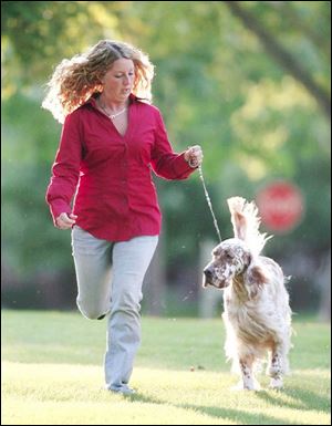Lindsey Kuhn, a top dog handler at 19, runs with her English setter Logan.