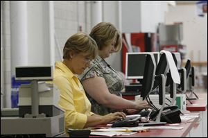 Kris Wong, left, and Lisa Pittman process membership applications in the week leading up to the Aug. 29 opening of the Costco Wholesale Corp. s store in Westgate Village.