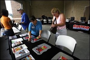 Gladys Wright, far left, speaks with Howard Nollenberger about a Costco membership while Theresa Otersen helps Cheryl Ball with an application at the soon-to-open wholesale club.