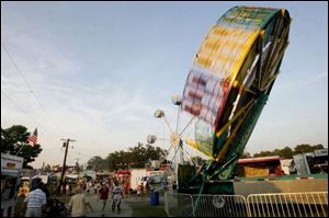 Fair-goers explore the midway on opening day, just a week after flooding struck the Findlay area. A cleanup effort beginning last Thursday restored sparkle to the fair buildings. 
<br>
<img src=http://www.toledoblade.com/assets/gif/weblink_icon.gif> VIEW: <a href=