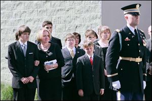 Karen Gillmor and her three sons, Paul Michael, left, Connor, and Adam, watch the honor guard place U.S. Rep. Paul Gillmor's coffin into a hearse for the journey to Pleasant Union Cemetery in his hometown of Old Fort in Seneca County.