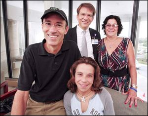THE BLADE Laurie Sarvo, right rear, will donate a kidney as part of a chain that allowed daughter Angela Heckman, center, to receive a kidney from Ron Bunnell, left. Surgeon Michael Rees, center, directs the program.