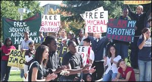 UT students Tiffany Howell of Cleveland, Robert Jennings of Lima, Ohio, and Brandon Chaney of Warren, Ohio, applaud speakers at the rally. They were among hundreds of people who gathered outside the UT Student Union for the student-led event. 
