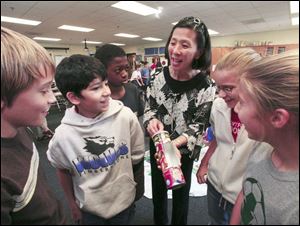Timberstone Junior High science teacher Rini Ng shows a solar hot dog cooker to, from left, Luke Gayer, 11; Kal Aridi, 11; Damon Ide, 12; Reba Darrin, 11, and Madison Edwards, 11. The students are teaching each other the merits of energy conservation. 