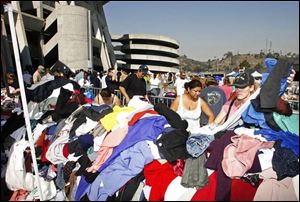 People displaced by the fires search through piles of donated clothing outside Qualcomm Stadium in San Diego. Thousands of evacuees took shelter at the stadium, home of the NFL s San Diego Chargers.
