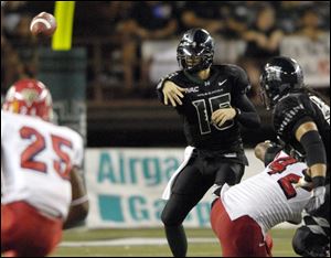 The Warriors' Colt Brennan zips a pass during a game against Fresno State. He tied the NCAA career mark for touchdown passes, throwing his 121st before being felled.