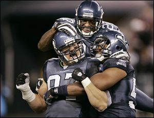 The Seahawks  Patrick Kerney gets congratulated by Jordan Babineaux, top, and Darryl Tapp
after sacking San Francisco s Alex Smith. Smith was sacked three times by the Seattle defense.
