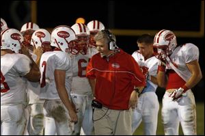 Eastwood coach Jerry Rutherford uses a timeout to discuss game strategy with Eagles players, who go up against Marion Pleasant tonight at Donnell Stadium in Findlay.
