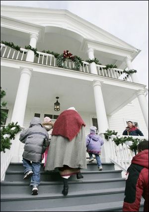 Guide Mary Frances Berger leads a group of visitors from the Sherman Elementary kindergarten into the Wolcott House Museum for a tour. The complex in Maumee has taken the theme 'Yes, Virginia, there is a Santa Claus'  for its display this holiday season.