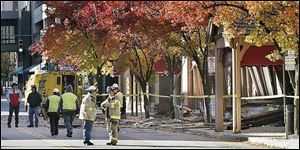Fire officials and utility crews inspect the scene outside the Renaissance Senior Apartments and Valentine Theatre complex on St. Clair St. in downtown Toledo.