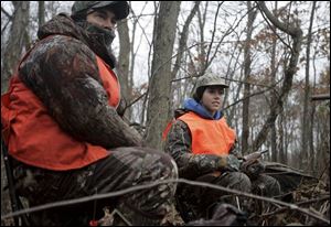 Carl Capestrain and his daughter Jessica, 17, keep watch for whitetail deer during Ohio's youth deer hunt earlier this month.They were hunting near Carrollton, southeast of Canton.