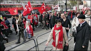 Toledo Mayor Carty Finkbeiner and his wife, Amy, walk past protesters in London. The couple paused frequently to mingle.