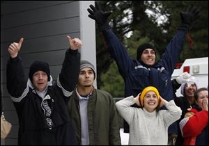 Friends and family members cheer as Frederick Dominguez and his son Christopher arrive by helicopter in Stirling City, Calif., after their rescue today. 