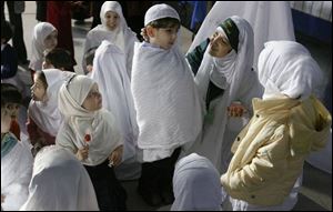 Prekindergarten teacher Roueida Hakki talks to Ali Jomma, 4, in Sylvania yesterday during the Toledo Islamic Academy s annual Hajj Day re-enactment of the Muslim pilgrimage to Mecca. 