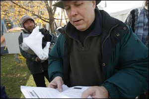 At a 2006 event, Ken Leslie, center, helped a group of homeless people, including James Jozwiak, left, obtain birth certifi cates.
