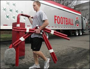 Tyler Carpenter, a student manager for the Ohio State football program, carries equipment to a semi-tractor trailer outside the Woody Hayes Center before it departed for New Orleans.
<br>
