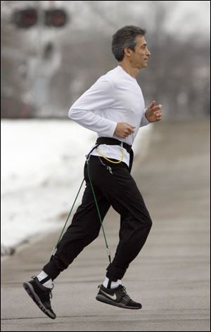 Joe Sparks of Perrysburg Township says his invention, the EZ Run Belt, promotes the proper exercise mechanics.