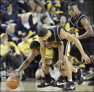 Michigan forward DeShawn Sims reaches for the ball in a battle with Iowa guard Tony Freeman. Sims scored 18 points.