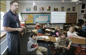 Math teacher Eric Ward leads an examination of his students' preliminary portfolios.