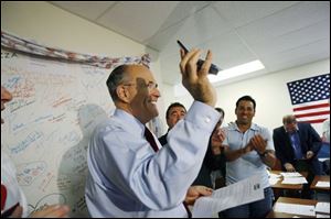 Republican presidential hopeful, former New York City Mayor Rudy Giuliani, talks to the girlfriend of volunteer Javier Manjarres, center, on the phone to encourage her to vote for him as he visits his Broward County campaign headquarters in Pompano Beach, Fla., on Tuesday.