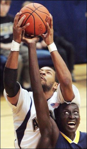 Akron's Chris McKnight rebounds over Toledo's Justin Anyijong last night at Rhodes Arena. McKnight had three rebounds.