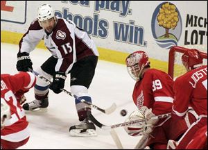 Colorado's Andrew Brunette tries to scoop the puck past the Red Wings' Dominik Hasek, who got his 80th career shutout.