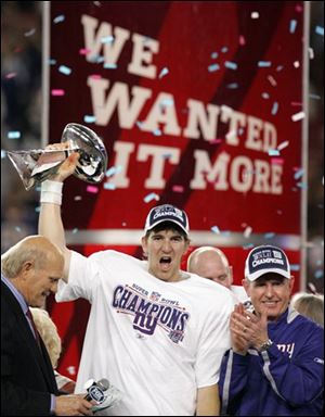 New York Giants quarterback Eli Manning celebrates with the Vince Lombardi Trophy alongside Giants head coach Tom Coughlin, right, and Terry Bradshaw after the Giants defeated the New England Patriots 17-14 in the Super Bowl Sunday. (ASSOCIATED PRESS)
<br>
<img src=http://www.toledoblade.com/graphics/icons/photo.gif> <b><font color=red>VIEW</b></font color=red>: <a href=