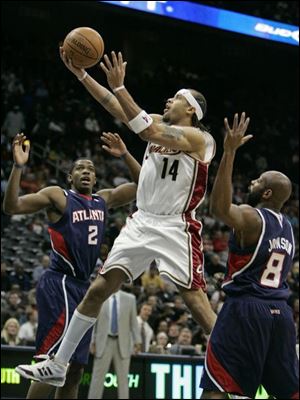 The Cavaliers' Ira Newble drives between Atlanta's Joe Johnson, left, and Anthony Johnson. Newble scored a season-high 18.