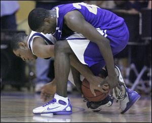 Khari Riley, right, who led Waite with 22 points and 10 rebounds, battles for a loose ball with Whitmer s Antwan
Willis. The Indians (13-4, 8-3 City League) earned the
right to face St. John s in the CL playoffs while the Panthers (14-4, 8-3) will match up with Libbey.