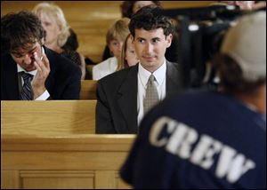 Blade reporter Ryan Smith along with other extras wait during a pause in the taping of the movie 