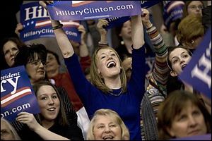 Angela Hitchock, lower left, 18, of Sylvania and Linnea Clausen, center, from Tiffin, a student at Otterbein College, show their support as Gov. Ted Strickland speaks at the Hillary Clinton campaign rally held at Ohio State University's French Field House on Thursday.