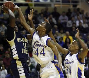 Libbey's William Buford (44) and Julius Wells defend against St. John's Tim Kynard. Foul trouble limited Buford to less than 20 minutes, but he still led the team with 15 points. (BLADE PHOTOS/JEREMY WADSWORTH)
<br>
<img src=http://www.toledoblade.com/assets/gif/TO17150419.GIF> VIEW: <a href=