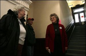 Volunteer guide Paula Crum, right, welcomes Avanell and Lester Morter to a tour of the Seneca County Courthouse yesterday. The 1884 Beaux Arts-style, sandstone courthouse in Tiffin was designed by noted American architect Elijah E. Myers. 