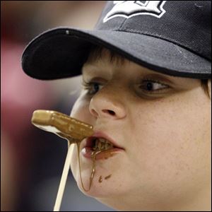 Slug: NBRN wonka21p  Date: 02/14/2008         The Blade/Andy Morrison       Location: Dundee       Caption: Chocolate drips from the face of Gene Miracle, 10, Dundee, as he eats a wafer at the Willy Wonka Chocolate Party at Dunee Branch Library, Thursday, 02/14/2008.         Summary: