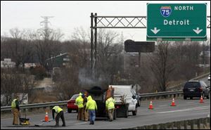 A state crew patches northbound I-75 yesterday between the Stickney-Lagrange interchange and Ottawa River Road.