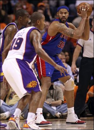 Rasheed Wallace looks to pass as he's guarded by Amare Stoudemire, left, and Raja Bell. Wallace paced the Pistons with 22 points.