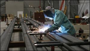 Bill Patterson welds steel rails in the high-bay fabrication shop, the crown jewel of Ironhead Marine Inc.'s new headquarters overlooking the Toledo Shipyard's dry dock. 