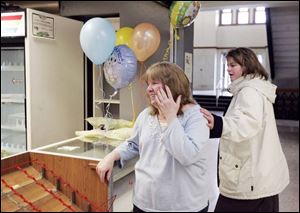 Coffee shop operator Jeannie Anderson-Snyder of Point Place receives encouragement from Toledo's Chris Mercer, right, on the last day for Jeannie's Coffee Shop in the Lucas County Courthouse. Ms. Anderson-Snyder closed the snack bar because she has more customers at a snack shop in Government Center. 