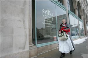 Tony Daniels carries what he can from his apartment in the LaSalle building to temporary living quarters. He received a letter yesterday from managers to evacuate the 91-year-old building because a short- circuit left the 131 units without power on Mon-
day, which happened to be Mr. Daniels' 63rd birthday. Managers advised residents to pack for a couple of days. 