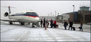 Passengers board an earlier Delta flight at Toledo Express Airport. The number of nonstops has been dwindling at the airport.
