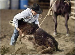 Cody McCartney, a high school senior, takes down a calf while practicing at his family's farm in Ottawa Lake, Mich. 