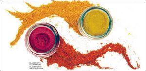 A jar of green curry paste, above right, with a tail of curry spice, and a jar of red curry paste with a tail of red curry spice.