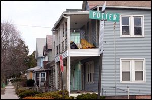 Bags of trash and debris are placed on the second floor porch of a house at Potter Street and Starr Avenue.