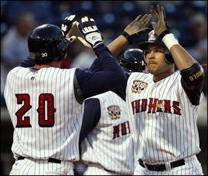 Matt Joyce (20) congratulates Erick Almonte after Almonte hit one of the Mud Hens' fours home runs last night against Charlotte.